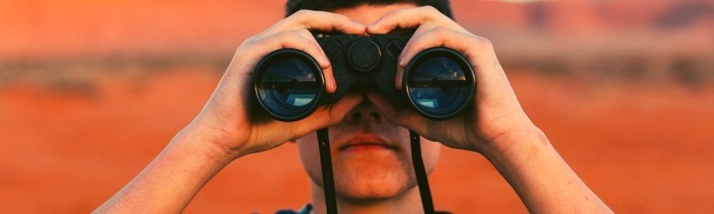 Young man looking through binoculars,